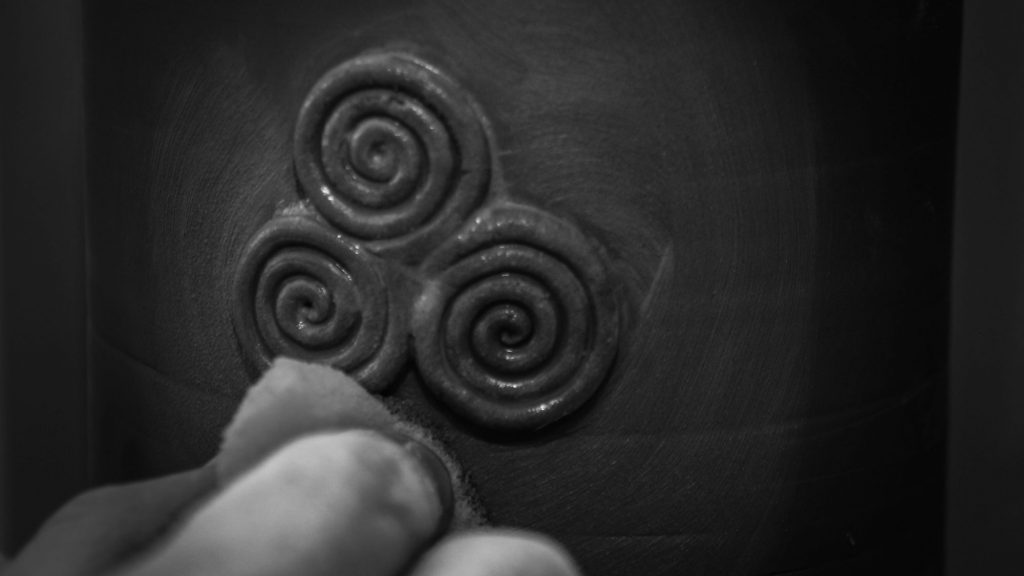 Irish Urn close up of trispiral as potter finishes off detailing - Urns for ashes