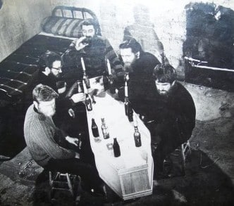 An Irish wake with men sitting around a coffin used as a table